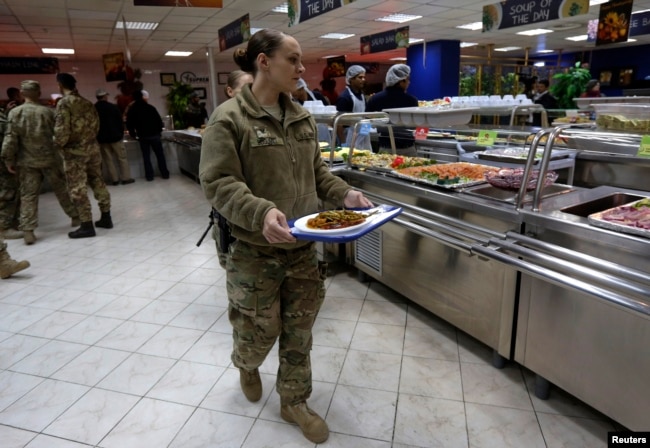 Një ushtare amerikane shihet me një pjatë me ushqime në bazën ushtarake të NATO-s në Kabul. Fotografi e nëntorit të vitit 2013, periudhë e Festës amerikane të Falënderimeve.